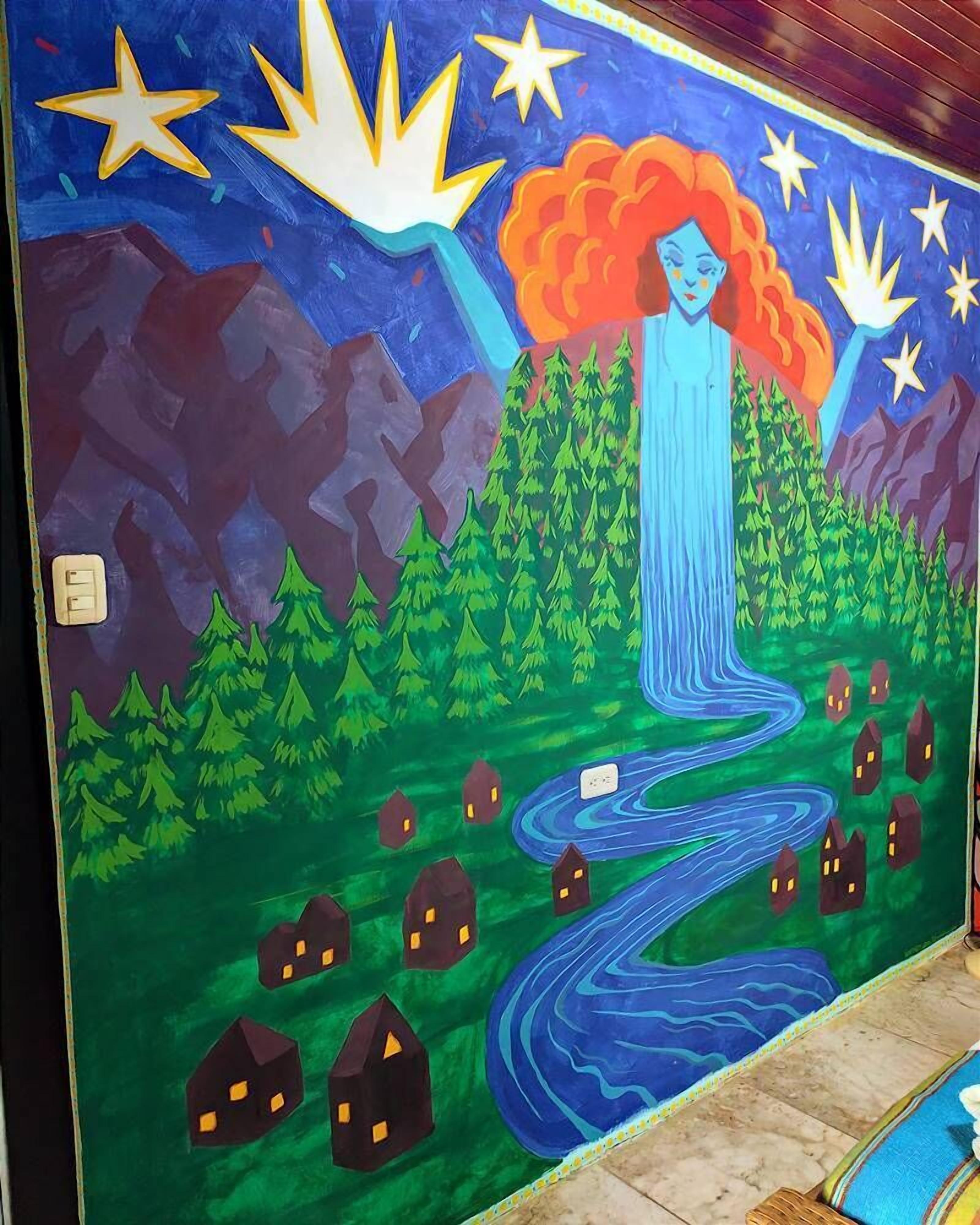 A mural with a central figure, a winding path, and houses.