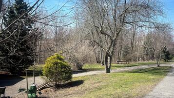 A park with a paved path, benches, and leafless trees under a clear blue sky.