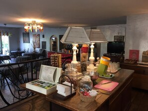 A dining area with a wooden table, various food items, and a television in the background. - Balladins Lyon Est (Saint-Quentin-Fallavier)