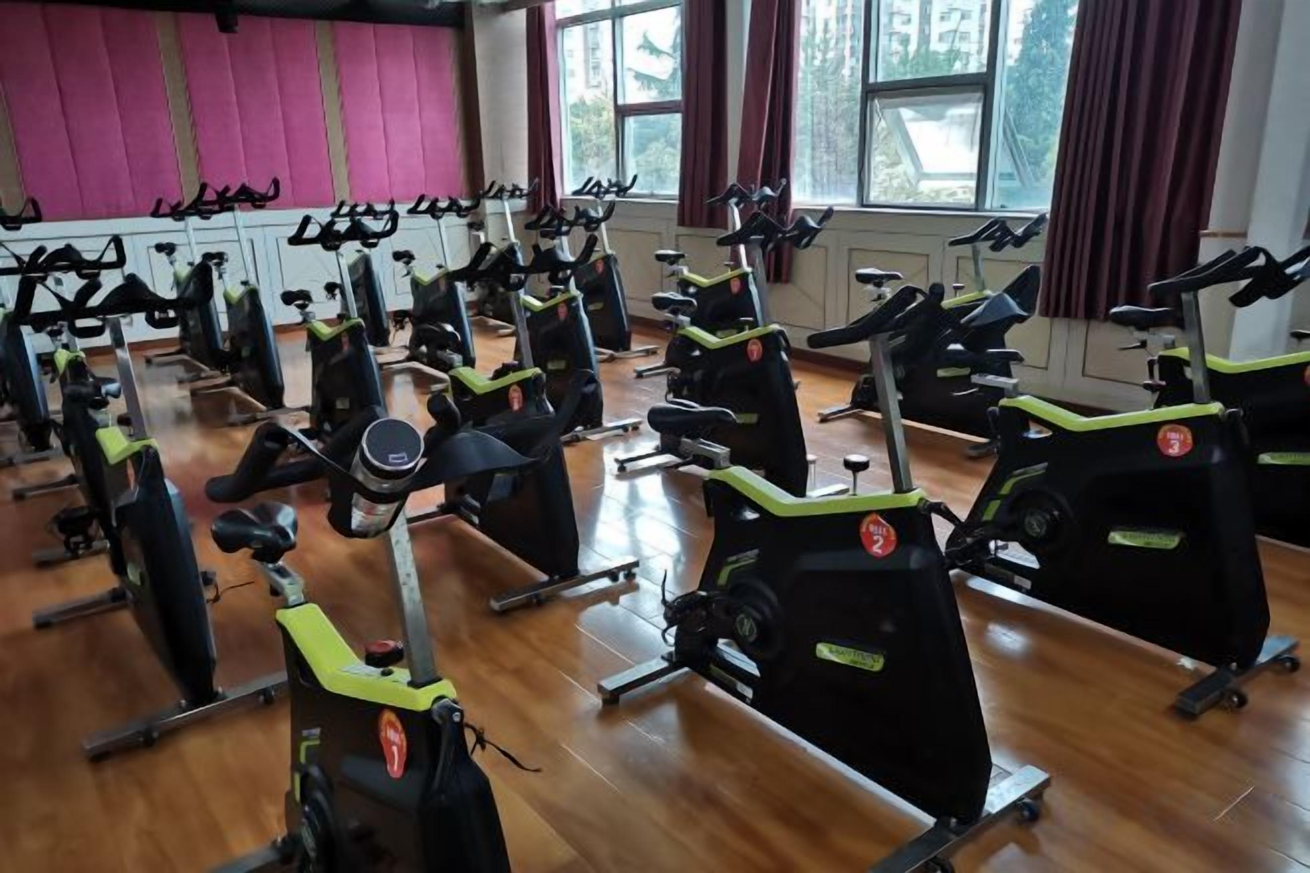 A gym with stationary bikes arranged in rows.