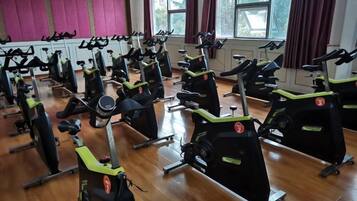 A gym with stationary bikes arranged in rows.