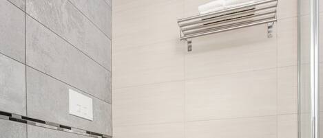 A modern bathroom with a bidet, a toilet, and a shower area.