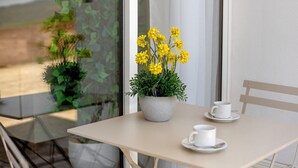 A table with a potted plant and two white cups.