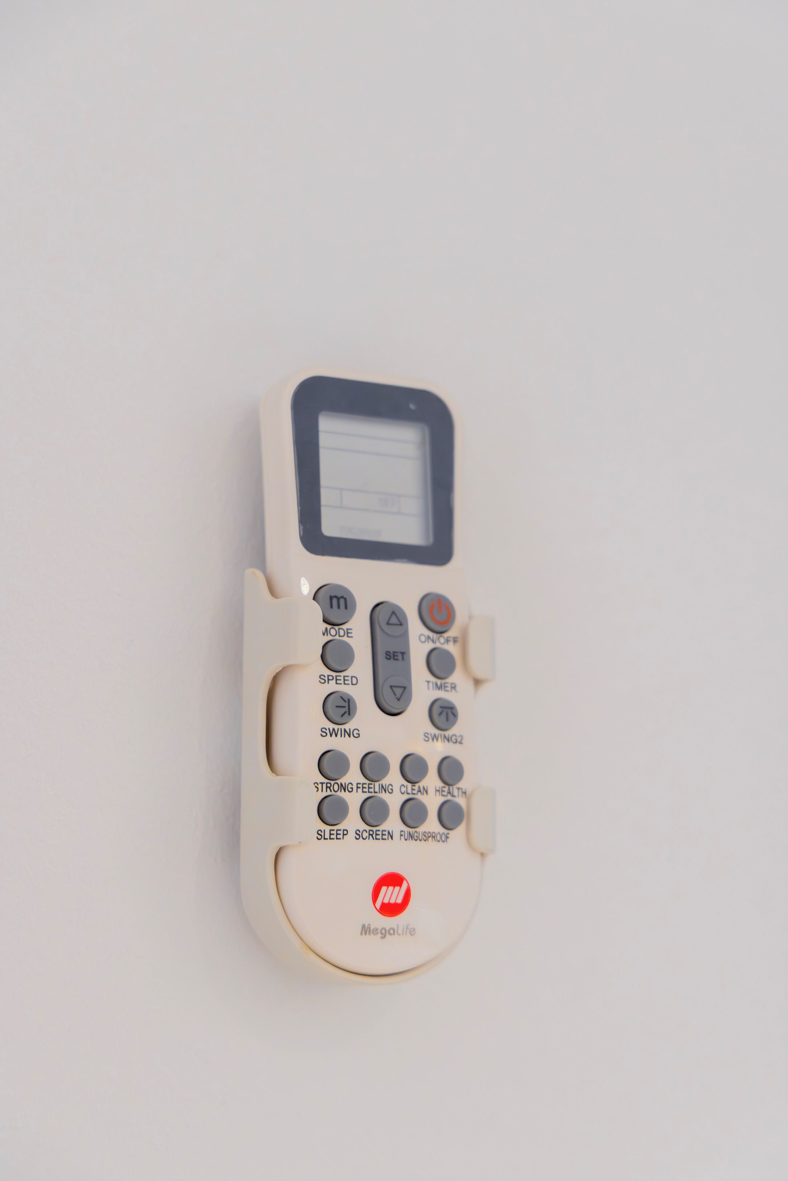 Un appareil électronique Megalife blanc, doté d’un écran et de plusieurs boutons indiquant différentes fonctions, comme le mode, la vitesse et la fonction veille.
