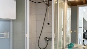 A bathroom with a shower, a sink, and a mirror.