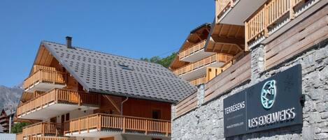 A hotel with multiple balconies, a stone facade, and a sign for 'Les Edelweiss'.