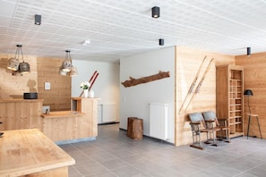 Un interior moderno con un mostrador de recepción de madera, una zona de estar y una escalera.