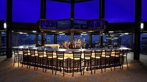 A bar area with a central bar and multiple seating arrangements. - 4BR A-Frame at Schuss Mtn | Torch Lake & Pool Access l Sleeps 11 (Bellaire)