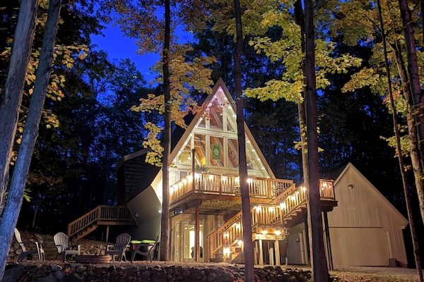 Secluded A-Frame Escape in the Woods | Close to Torch Lake + Pool Access at Lakeview Hotel. Spend your days on the water, relax by the pool, and unwind on the spacious deck surrounded by trees—your peaceful summer retreat starts here.