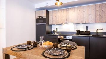 Une cuisine moderne avec des meubles en bois, un four encastré et un évier.
