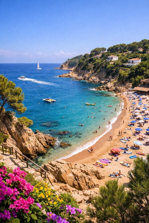 A coastal beach with clear waters, boats, and beach umbrellas.