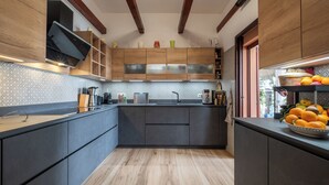 Eine moderne Küche mit dunklen Schränken, Holzboden und einem eingebauten Ofen.