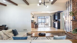 Ein modernes Wohnzimmer mit Sofa, Couchtisch und Blick in die Küche und den Essbereich.