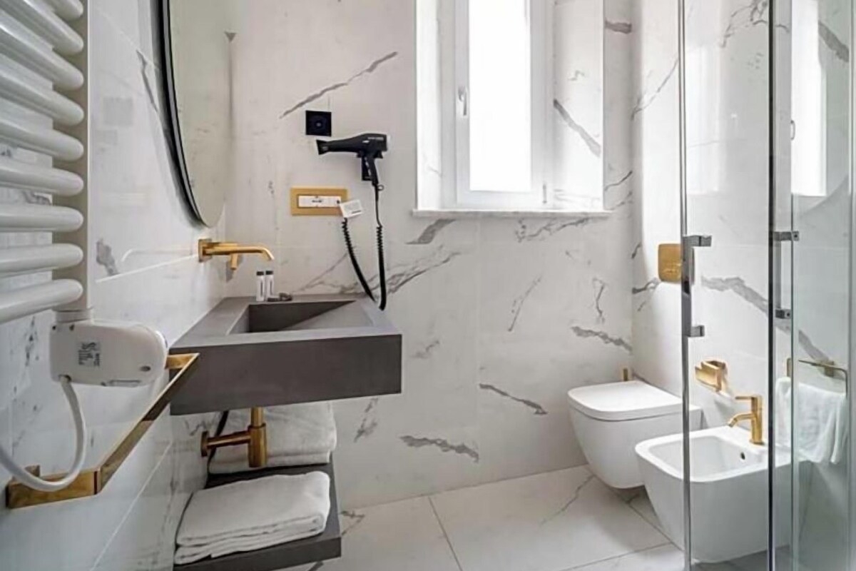 A modern bathroom with a glass shower enclosure, a vanity with a sink, and a toilet.