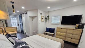 A hotel room with two beds, a television, a dresser, and a door leading to a balcony. - Crashpads (Orlando)