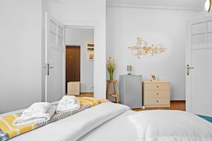 Una camera d'albergo con un letto, una cassettiera, una scrivania e un elemento decorativo a parete.
