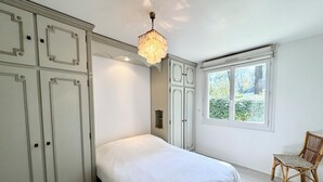 Un dormitorio con una cama, una ventana y una silla.