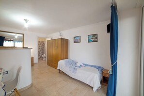 Un dormitorio con cama, armario, baño y espejo.