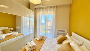 Habitació d'hotel amb un llit gran, un mirall, una finestra amb vistes i un radiador.