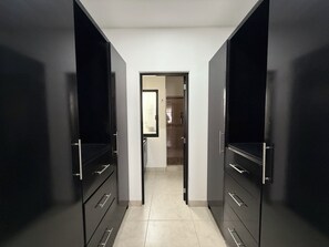 Stylish hallway leads to a well-organized room with a cabinet and tiled floor.