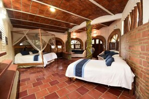 A room with two beds, a brick wall, and a wooden ceiling. - Jardin De Playa Sayulita (Sayulita)