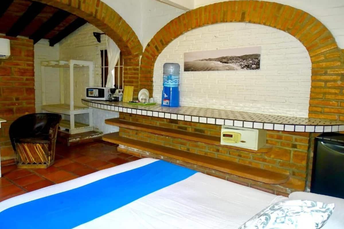Una habitación con piscina, chimenea de ladrillo y microondas en la encimera.