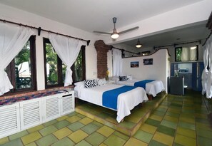 A room with two beds, a ceiling fan, and a small kitchenette. - Jardin De Playa Sayulita (Sayulita)