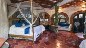 A room with a four-poster bed, a bench, and a fan. - Jardin De Playa Sayulita (Sayulita)