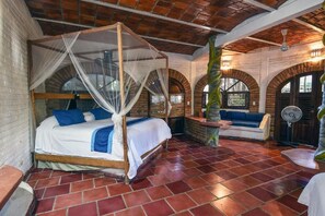 A room with a four-poster bed, a bench, and a fan. - Jardin De Playa Sayulita (Sayulita)