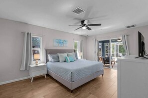 A bedroom with a bed, a ceiling fan, a window, and a television. - Sunny Cape Coral 4BR Heated Pool & Screened Lanai (Cape Coral)