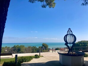 A park with a metal sculpture, a bench, and a view of the sea. - Monolocali Da Vinci (Falconara Marittima)