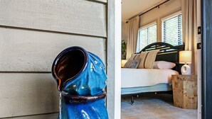 A blue ceramic fountain outside a room with a bed and a window.