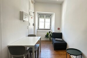Un petit espace de vie moderne comprenant un coin repas, un canapé et une petite table.