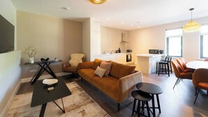 Un appartement moderne comprenant un espace de vie, une cuisine et un coin repas.
