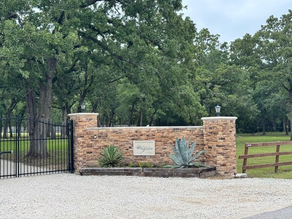 A stone wall with a sign reading "Wagonade" and a metal gate.