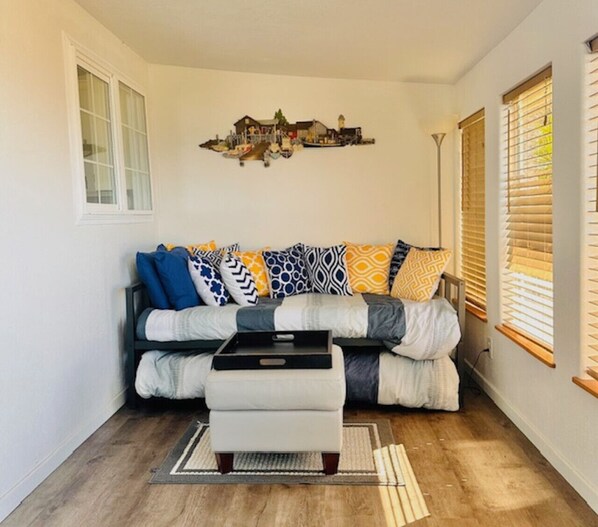 A living room with a sofa, ottoman, and a decorative wall piece.