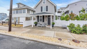 Un immeuble résidentiel de deux étages, doté d’un porche, d’un petit jardin et d’une clôture blanche.
