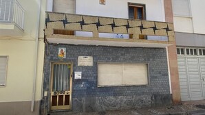 Ein Gebäude mit Kachelfassade, einem schmiedeeisernen Eingang und einem kleinen Balkon.