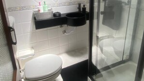Ein kleines Badezimmer mit Toilette, Waschbecken und Duschbereich.