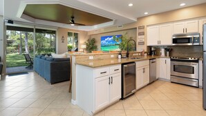 Una cocina moderna con armarios blancos, electrodomésticos de acero inoxidable y una isla grande.