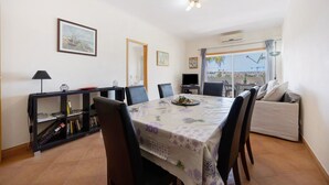 Un comedor con una mesa, sillas, una estantería y un sofá.