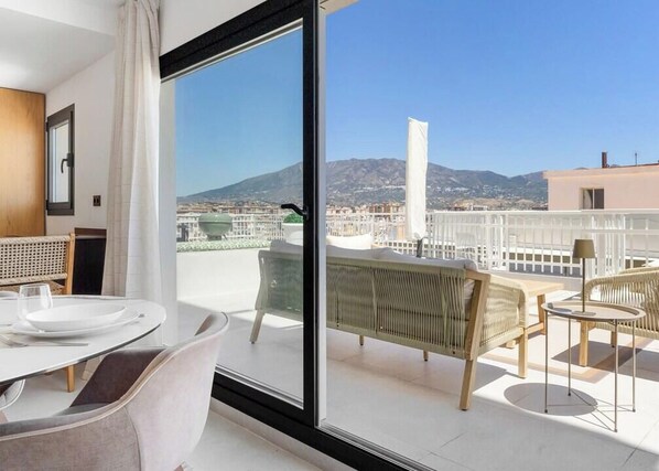 A balcony with a view of a cityscape and mountains. - Las Cuevas | Beachfront - Sea View - Terrace (Fuengirola)