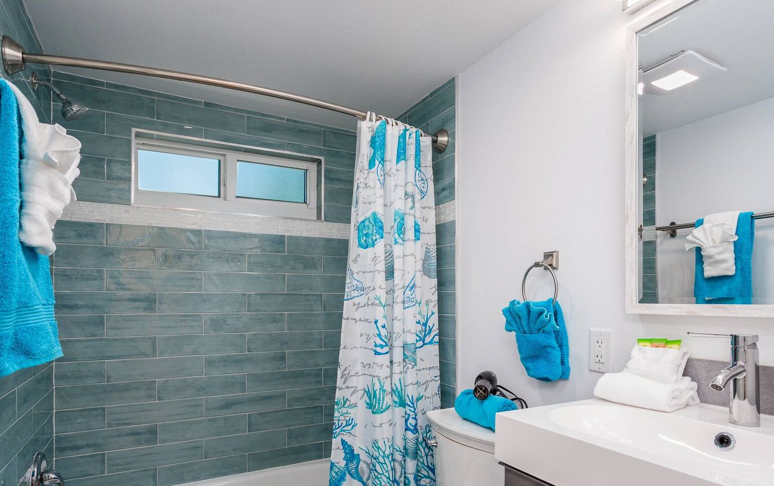 A bathroom with a shower, a sink, and a mirror.