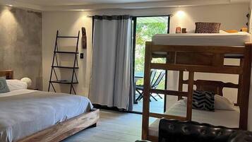 Ein Schlafzimmer mit einem Bett, einer Holzbank, einem schwarzen Lederhocker und einer an der Wand stehenden Leiter.
