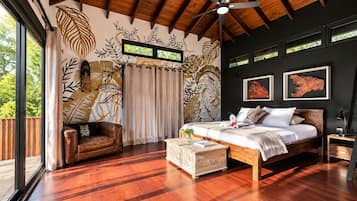 Un dormitorio con una cama grande, techo de madera, vista por una ventana y una pared con diseños de hojas.