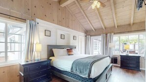 A bedroom with a bed, nightstands, a dresser, and a window with curtains. - La Jolla Historic Gem | Hot Tub, Game Room, Garden Oasis w/ Firepit & Courtyard Dining (La Jolla)