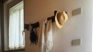 A wooden bed in a room with a window, a wall-mounted hat, and a thermostat. - Room 'Cùcu' with Shared Garden, Wi-Fi and Air Conditioning (Quargnento)