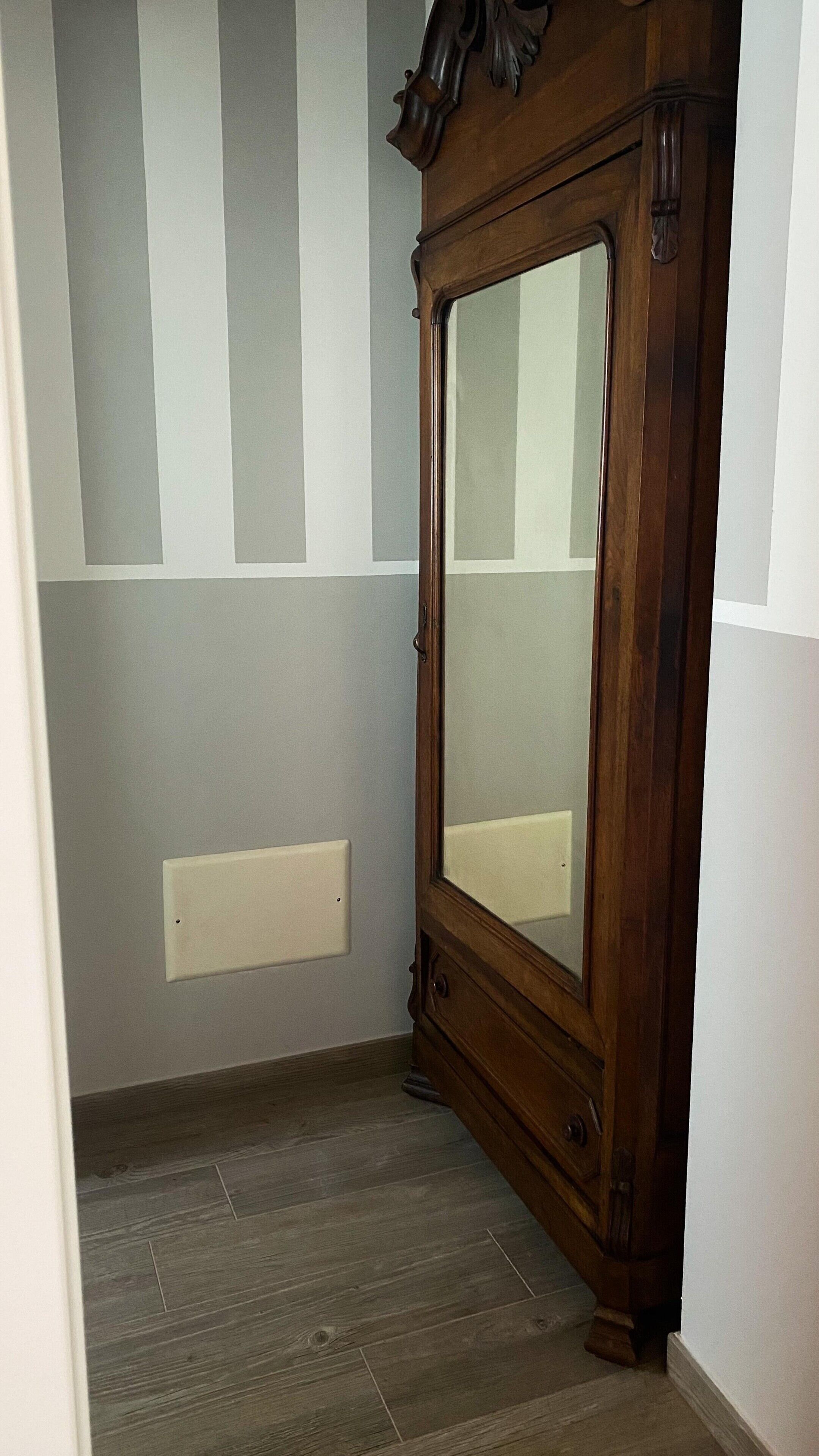Ein Flur mit einem Holzschrank, einem Lichtschalter und einer Wandleuchte.