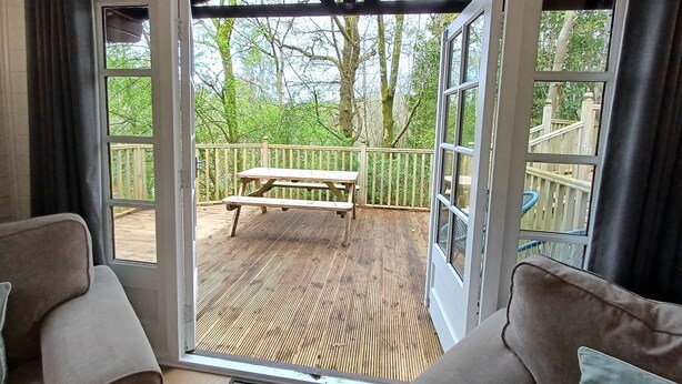 Ein Zimmer mit einer Schiebetür und Zugang zu einer Terrasse mit Picknicktisch.