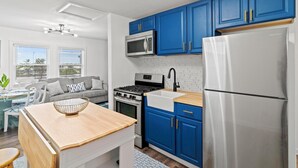 A modern kitchen with blue cabinets, stainless steel appliances, and a wooden island. - Cozy 2 Bedroom with a view with WiFi, AC (Seaside Heights)